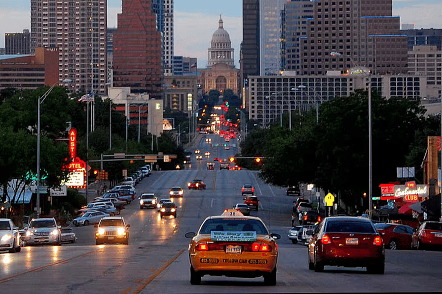 Downtown Austin and the State Capitol as seen from Congress Avenue. The house is tucked away on a private drive behind the Austin Motel (red neon sign on left)