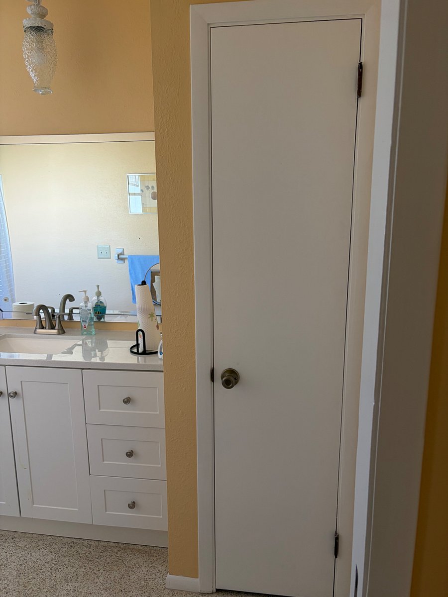 Bathroom vanity in bathroom with walk in shower and linen closet.