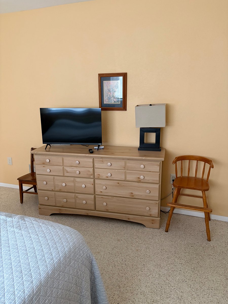 Dresser in bedroom with walk in shower.