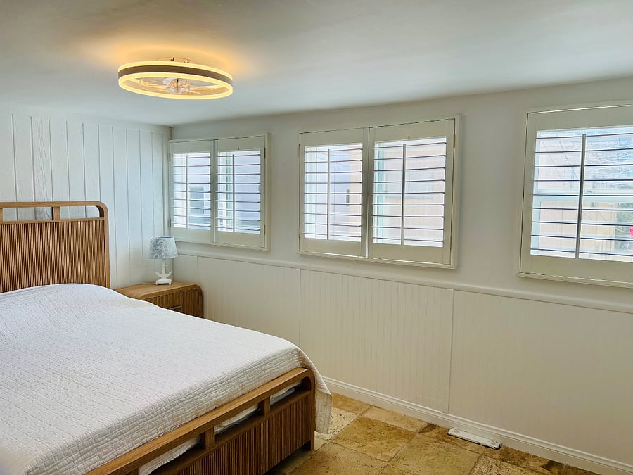 This is the guest room with sunny windows on one side and interior shutters on the other