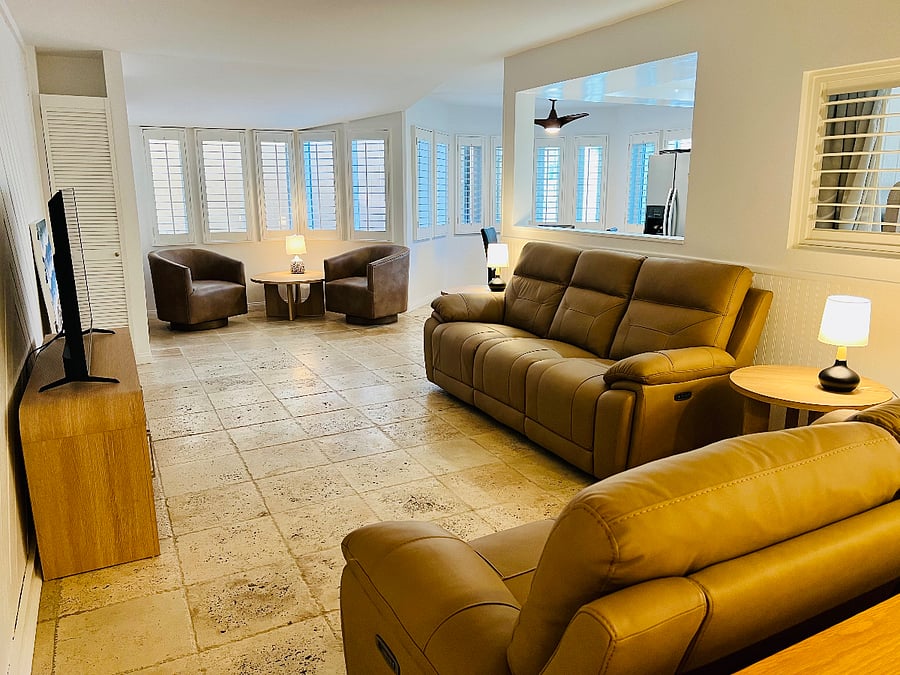 Living room, TV, lounge seating leads to the kichen in this photo