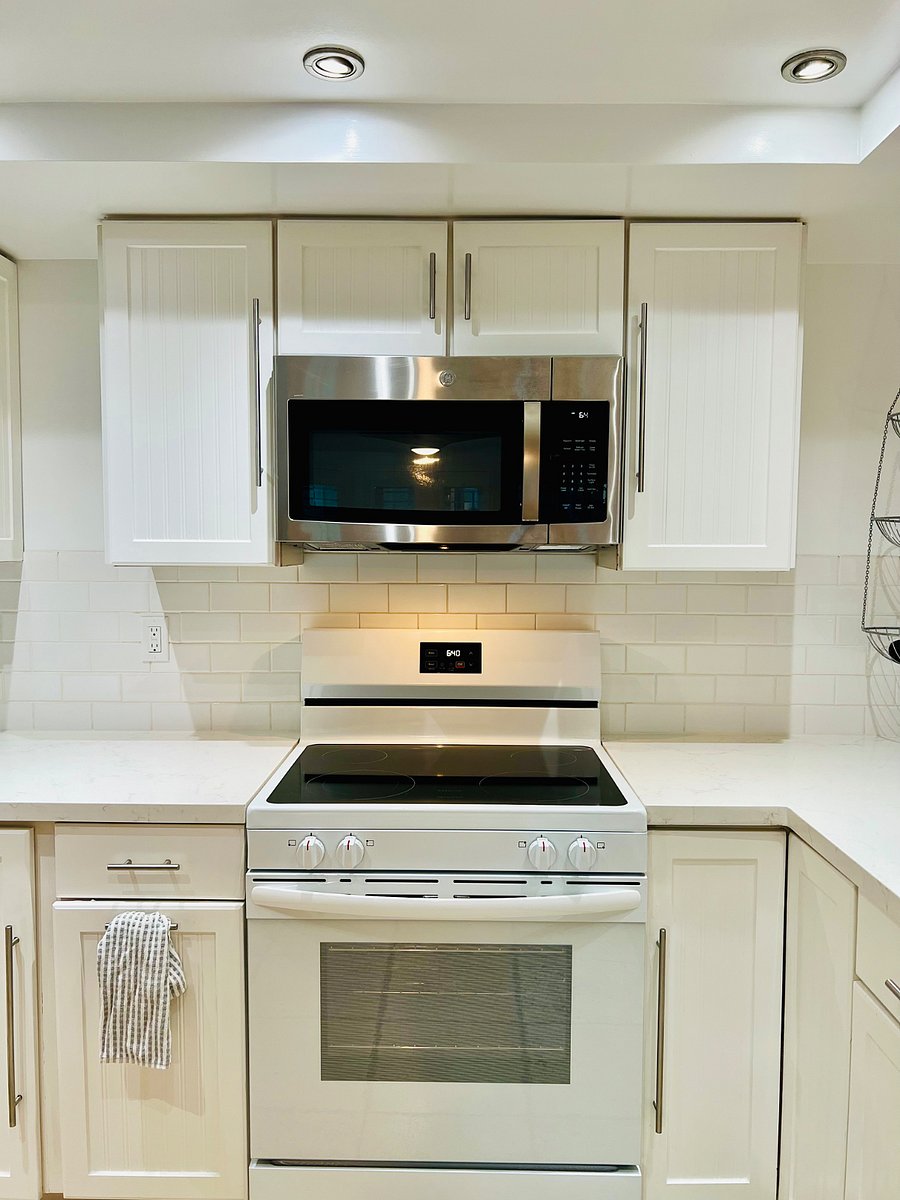 Clean white Quartz counters and cabinetry throughout the kitchen