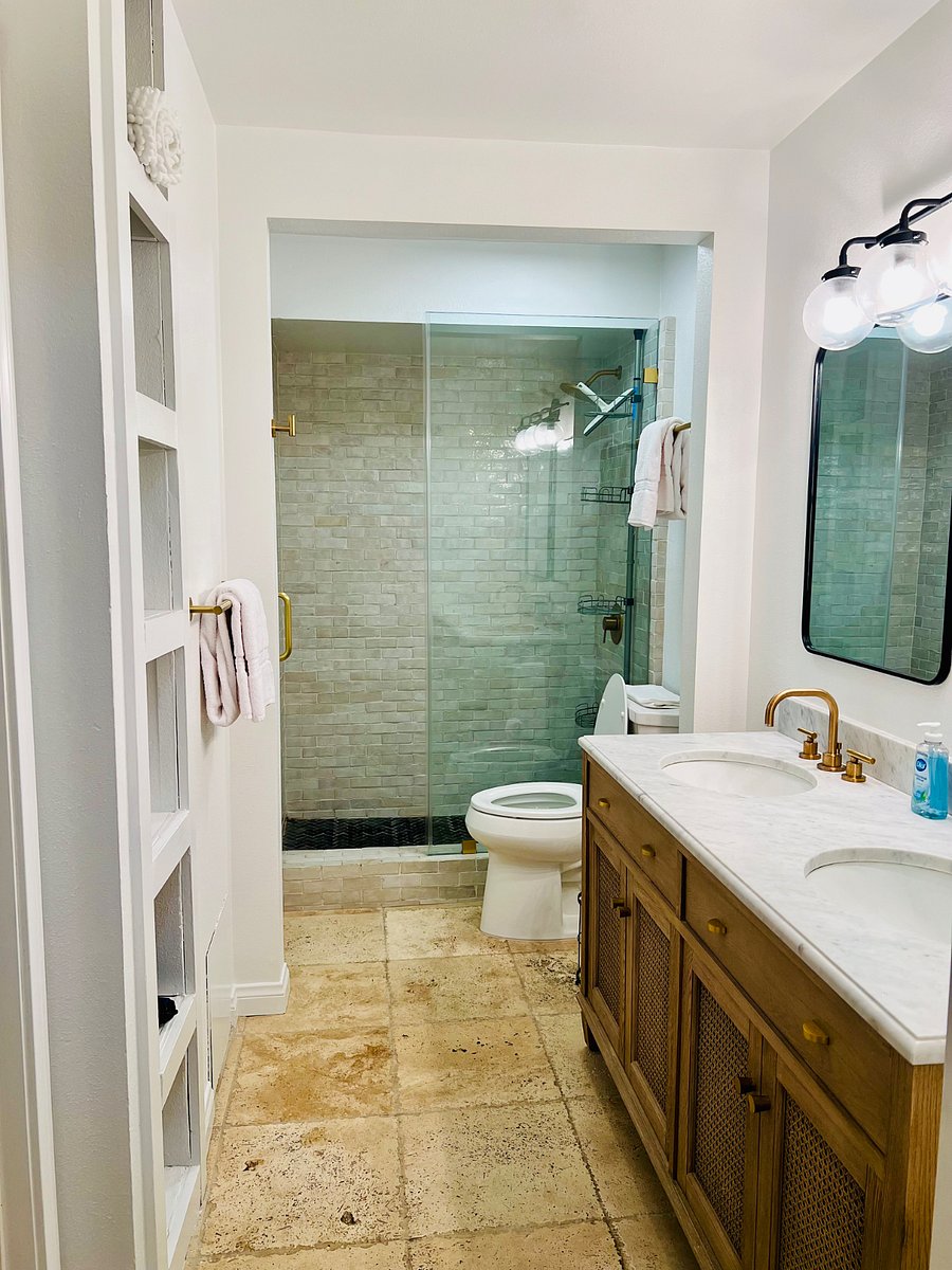 Primary bathroom glass-enclosed shower stall and new power-flush commode