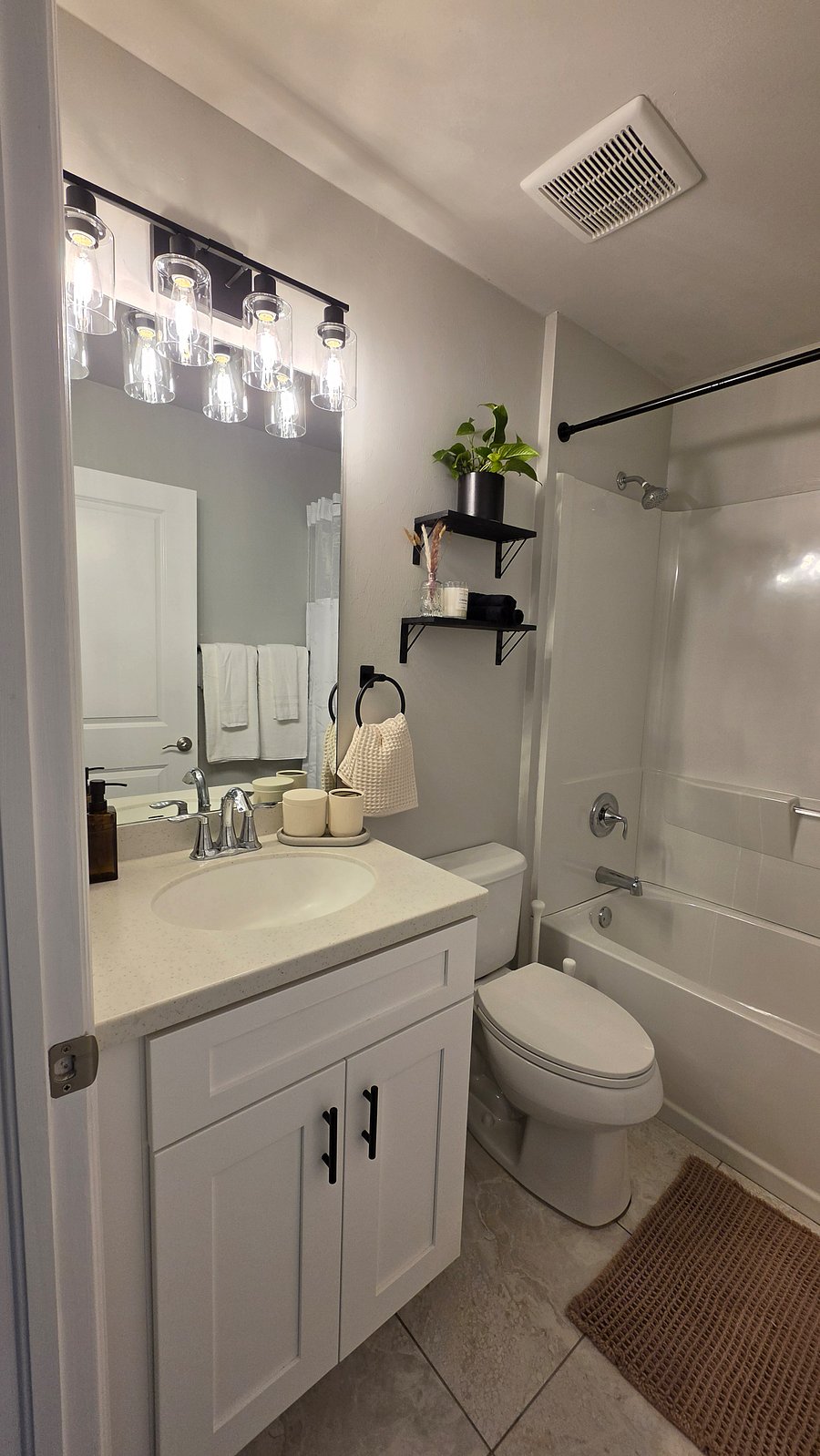 Modern bathroom with a walk-in shower.  Dispenser with shampoo, conditioner, and body wash.  Fresh towels, cotton pads, and swabs provided.  Includes a hair dryer and a makeup mirror for your convenience.  Clean, comfortable,Well and guest ready.
