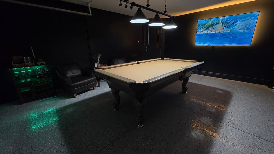 Game room located in the garage with comfortable temperature controlled by a mini-split system.  Features an epoxy floor, stylish lighting, pool table, dartboard, board games, TV, and a bar - perfect for relaxing and having fun.