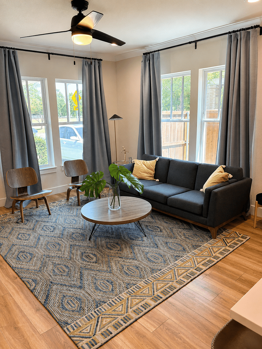 Bright, modern living room with comfortable seating, a large smart TV, and plenty of natural light. A clean, welcoming space to relax, stream your favorites, or gather after a day exploring Dallas.