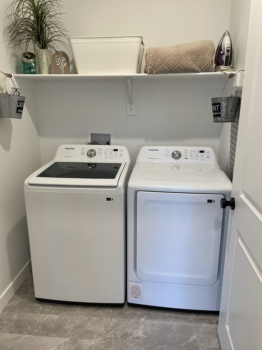 Laundry room including iron and ironing board.