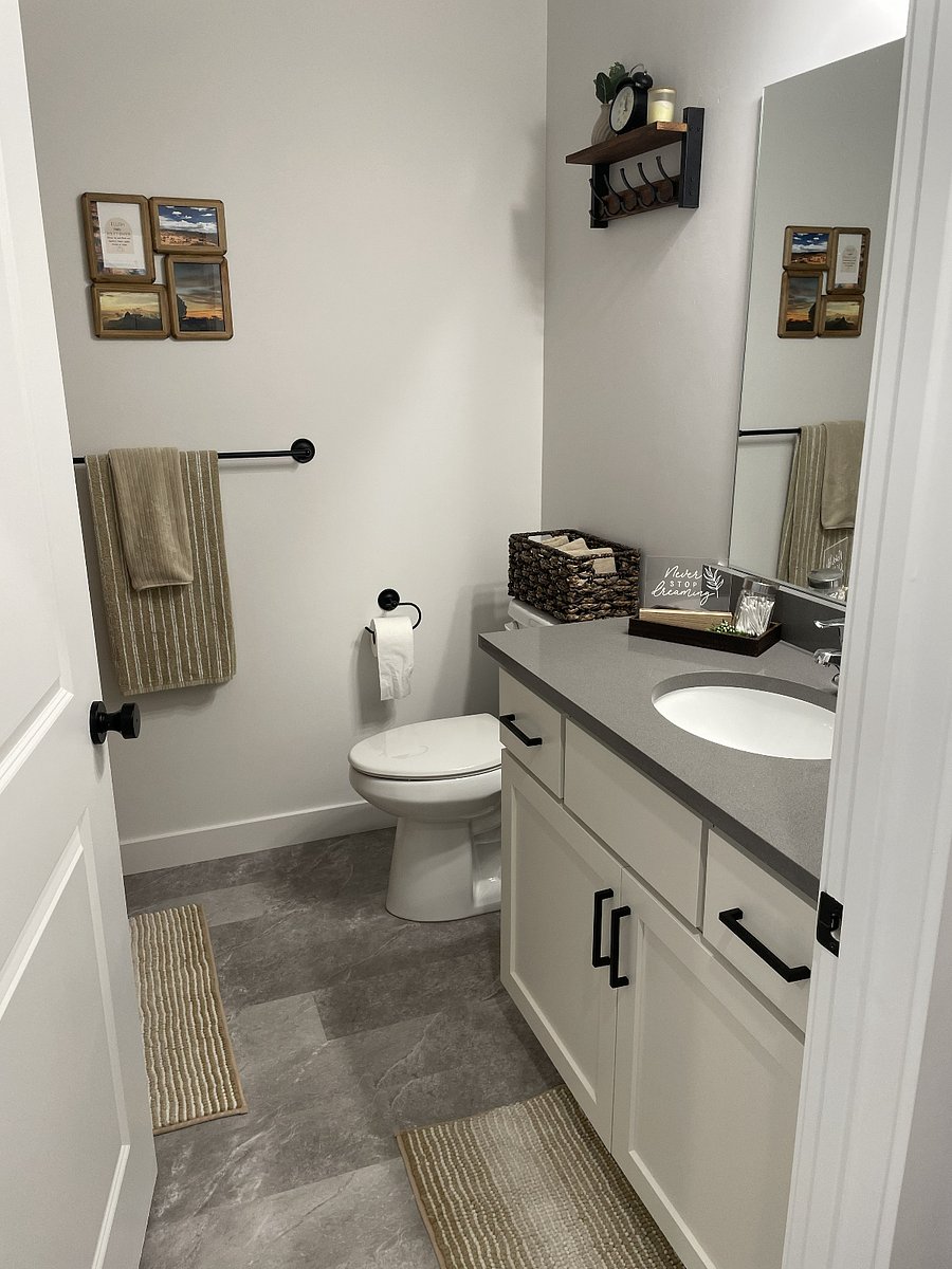 Bathroom with bathtub and shower with extra linens and storage shelves.