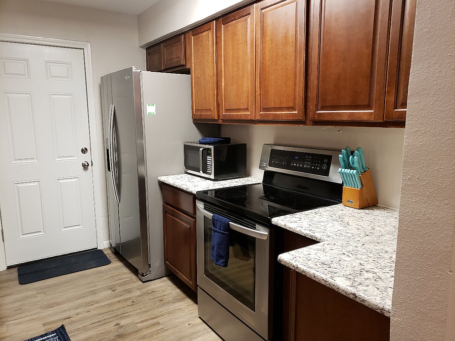 kitchen with door to back patio and carport