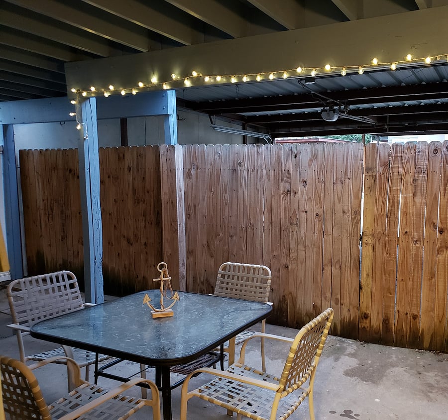 enclosed patio with carport behind it