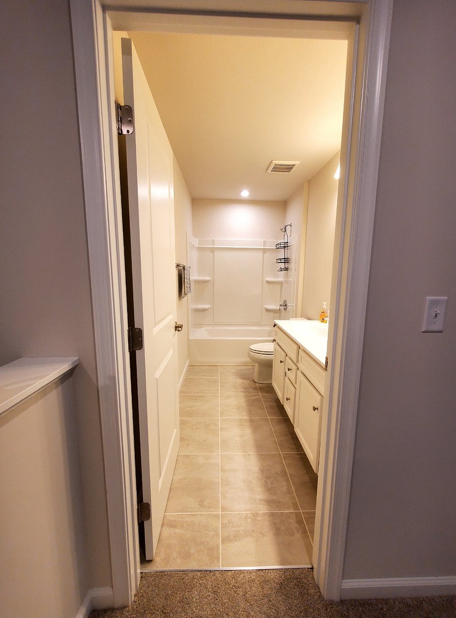 Private bathroom with tub and double sink vanity.