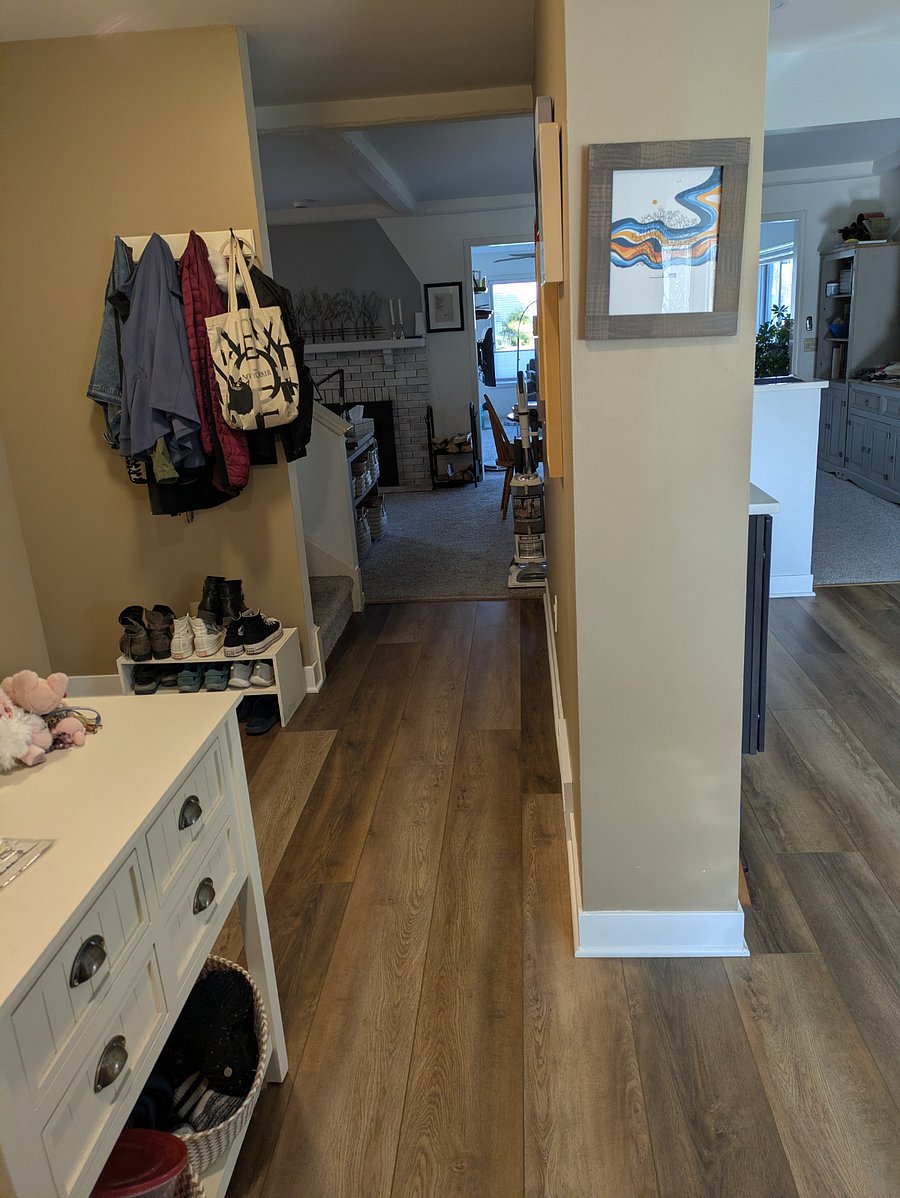 Front entryway with coat hooks, shoe rack, and access to a coat closet, half bath, stairs, kitchen, and the rest of the house.
