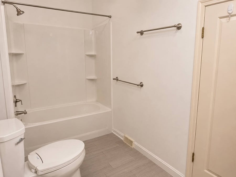 Upstairs bathroom has a tub/shower and doors to both the primary bedroom and the hallway.
