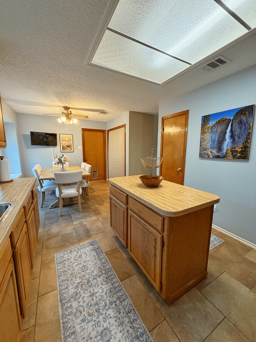 Kitchen view of pantry, laundry, garage, smart tv + kitchen ceiling fan! The kitchen table has a leaf to expand 2 additional seats.