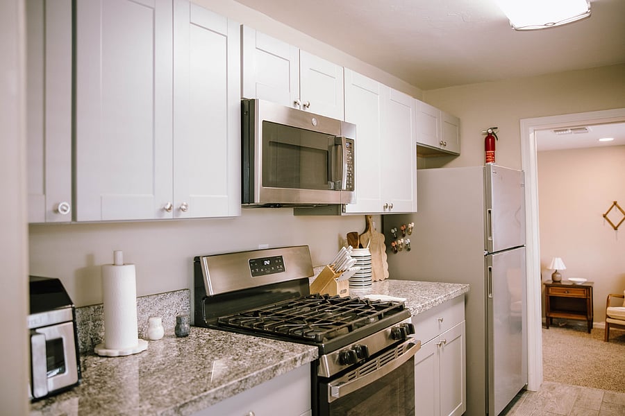 Shared kitchen with gas-range stove, microwave, fridge, freezer and air fryer.