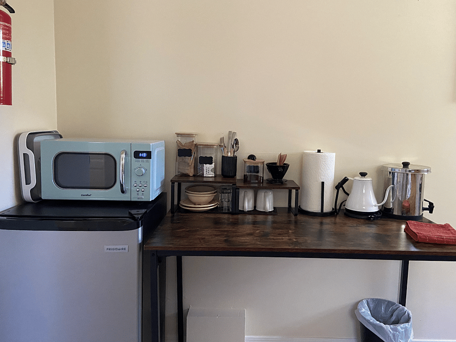 Microwave, mini fridge, and coffee station