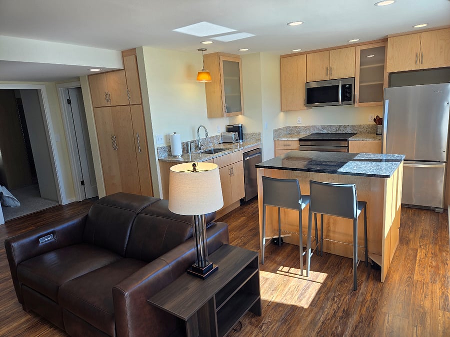 Full kitchen includes induction stove with microwave exhaust hood that is vented to the exterior.