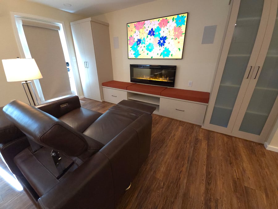 Rotating artwork fills the space through The 65" Frame 4K TV. Electric fireplace and bench seating adds cozy comfort. Electric headrest and footrest allows for open spaces when not in use. Door has blackout shade when needed.