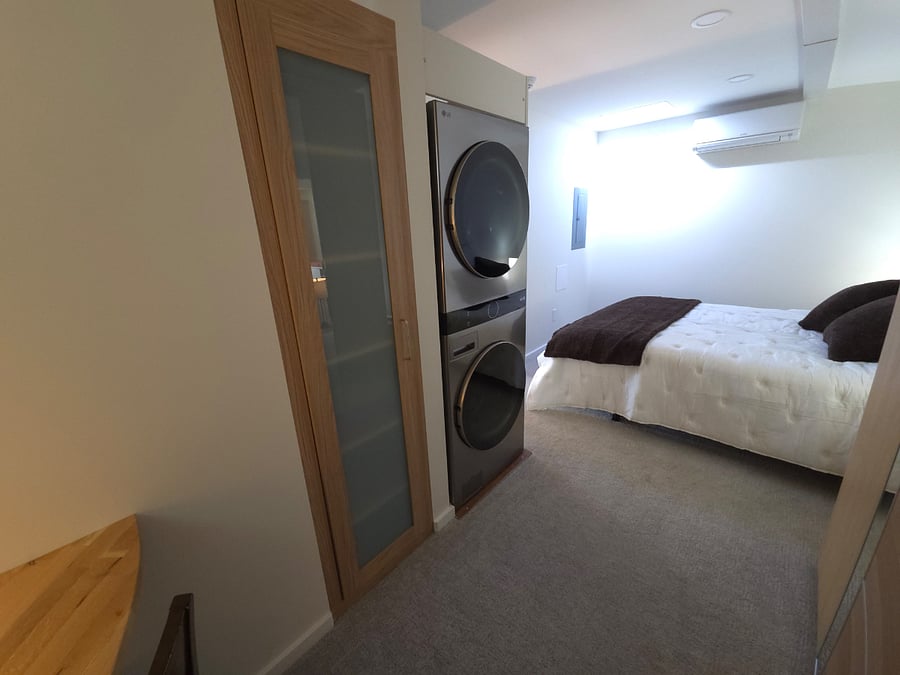 Towel and linen built-in cabinet next to a full-size washer dryer is beyond convenient.