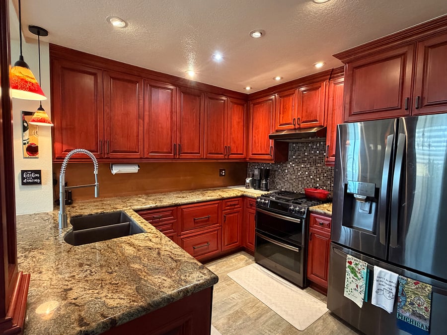Upgraded kitchen with granite counters, gas cooking, and abundant cabinetry.