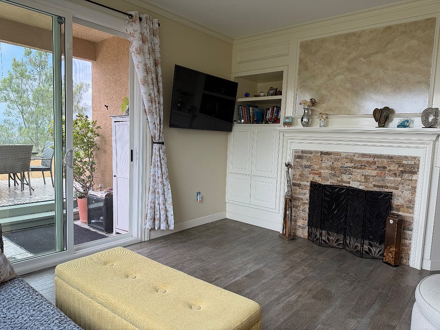 Bright living room with gas fireplace, smart TV, patio access, and beautiful views.