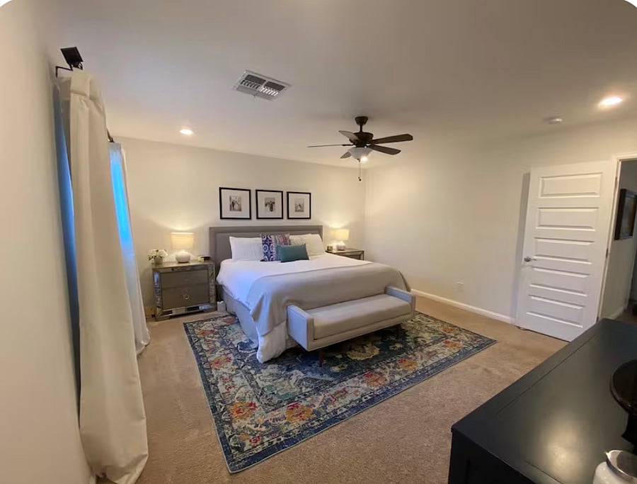 Primary bedroom with walk-in closet, TV, bathroom