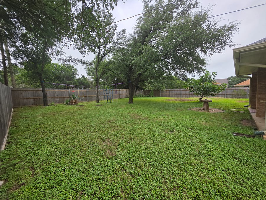 Fenced backyard with both double and single gates.