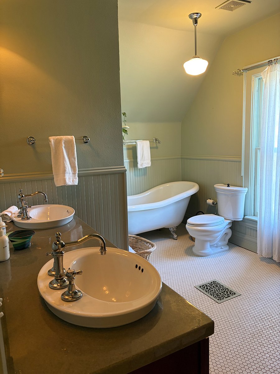 Primary bathroom featuring a clawfoot tub, double sinks, and a large shower