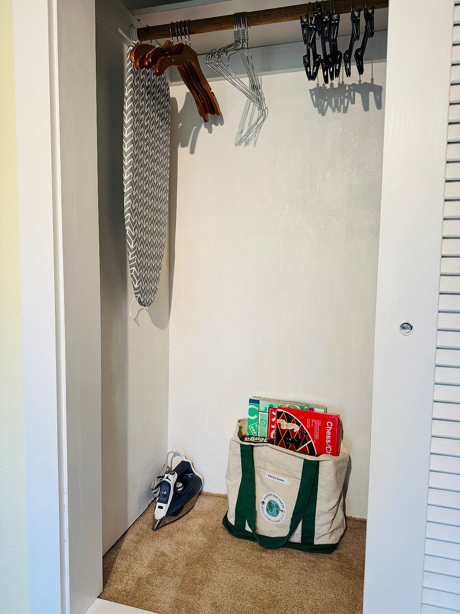 a big closet with hangers, iron, iron table, life size games , ...