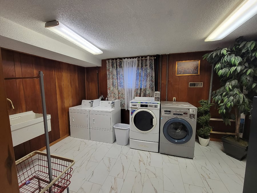 Large double sink and vintage laundry cart for convenience.