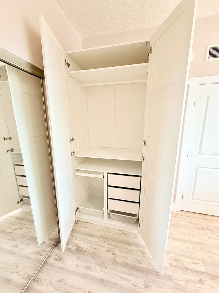 Custom wardrobe with hanging pants accessory, pull-out baskets, and drawers.