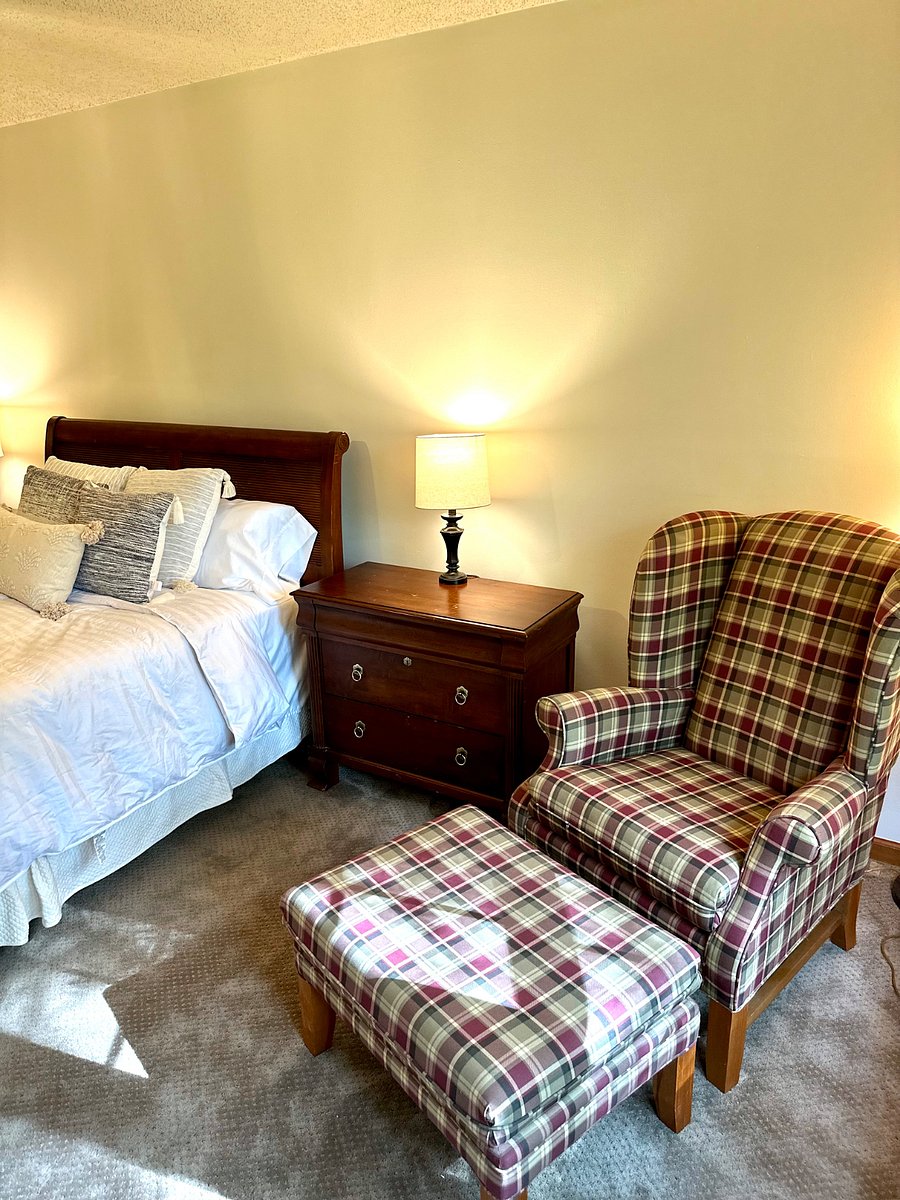 Bedroom-4 Downstairs. Queen bed with dresser and two nightstands. Comfy reading chair by the window.