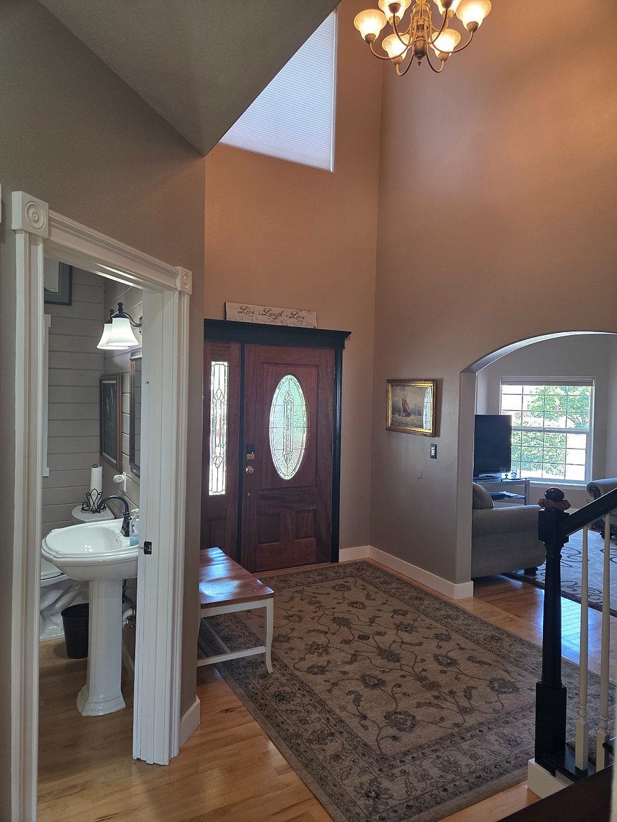 Walk into the entry to an airy and high-ceiling area with bench.