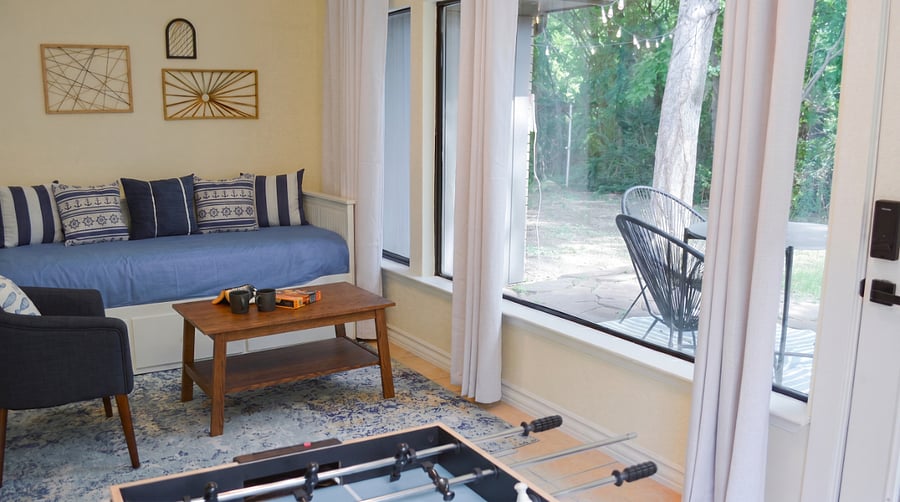 Sunroom with trundle bed sleeping 2 on twin mattresses ideal for families or groups needing extra sleeping space. Direct door access to private backyard patio. Foosball table and board games also in this room.