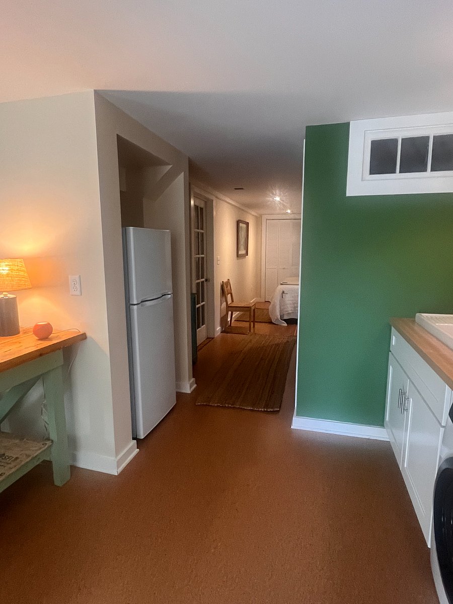 Hallway with refrigerator, shelving, microwave.