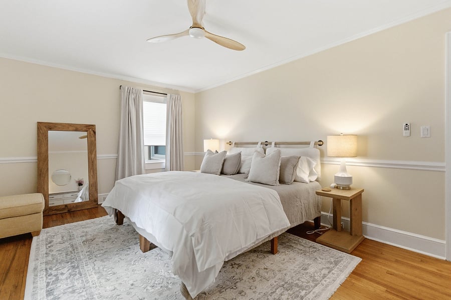 Primary bedroom 2 with split king bed, closet, dresser, full length mirror, premium bedding, blackout curtains.