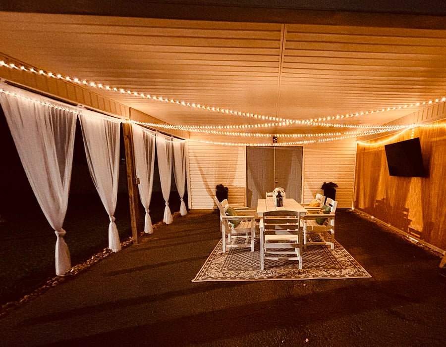 The backyard is designed as an extension of the homes living space, offering a covered alfresco dining area. A mounted outdoor TV adds an extra layer of comfort and entertainment.