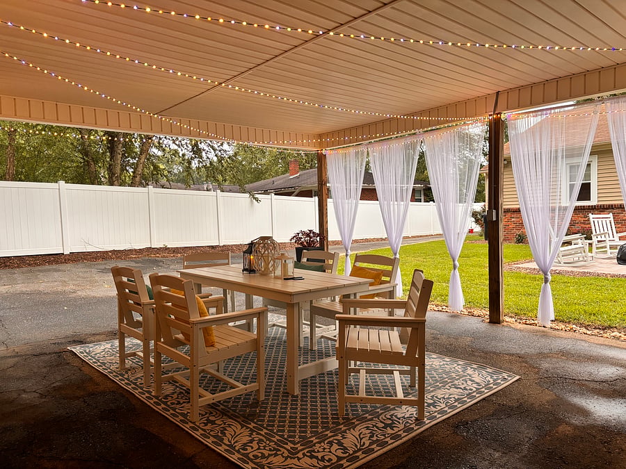 The backyard is designed as an extension of the homes living space, offering a covered alfresco dining area. A mounted outdoor TV adds an extra layer of comfort and entertainment.