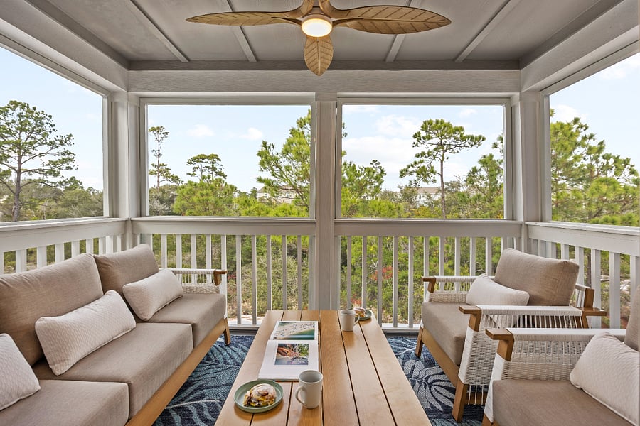 Screened in balcony with ceiling fan and comfortable furniture