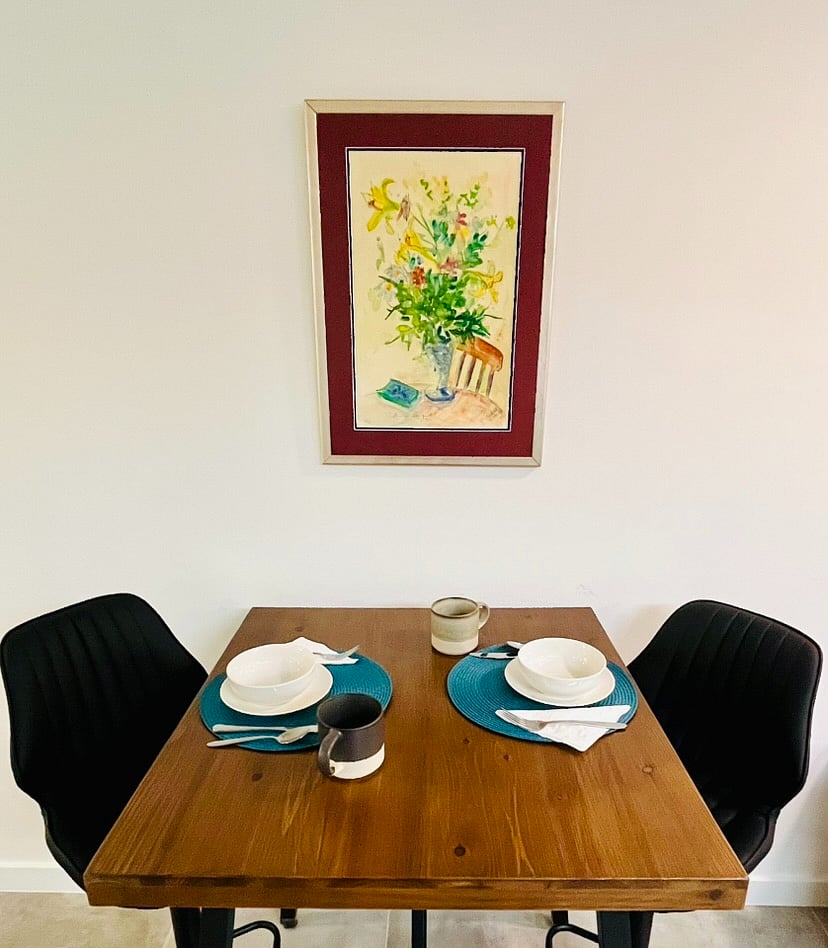 This table is counter height with adjustable chairs and doubles as an island.  It easily seats for and can elevate the dining experience and has a view to the television.