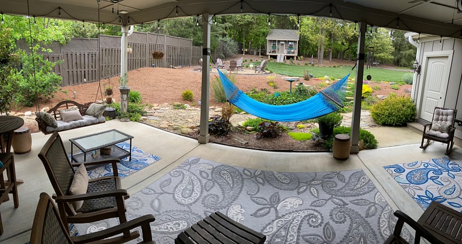 OUTDOOR LIVING SPACE: Large, private covered back porch with a hammock and overlooking the private fenced-in back yard and firepit - the perfect sanctuary to unwind after a long day at the office.