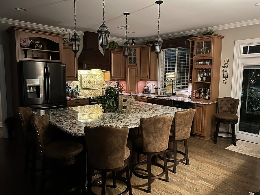 FULLY APPOINTED KITCHEN: Wide view showcasing the main cooking range, refrigerator, integrated liquor bar area, center island and sink. Full culinary access included!