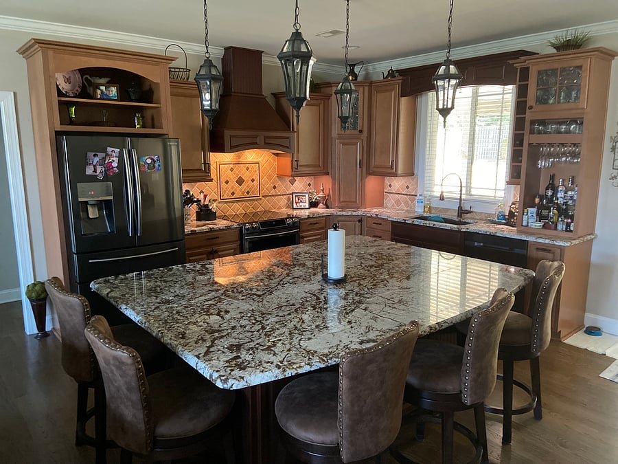FULLY APPOINTED KITCHEN: Wide view showcasing the main cooking range, refrigerator, integrated liquor bar area, center island and sink. Full culinary access included!
