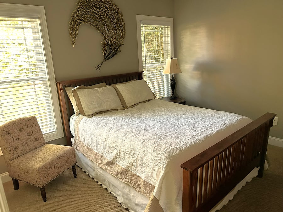 YOUR PRIVATE SANCTUARY: Premium queen-size bed and a comfortable accent chair, styled for maximum relaxation and a cozy, boutique-hotel feel.