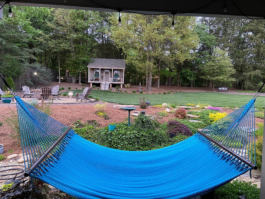 OUTDOOR LIVING SPACE: Large, private covered back porch with a hammock and overlooking the private fenced-in back yard and firepit - the perfect sanctuary to unwind after a long day at the office.