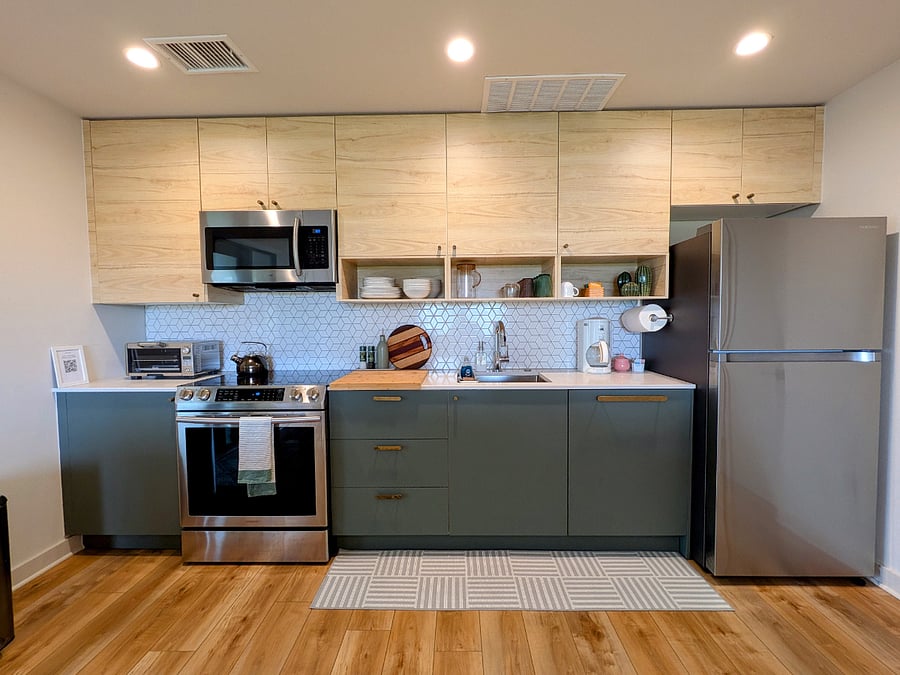 Fully equipped kitchen with full size fridge and range oven, microwave, dishwasher, coffee maker, toaster oven, and tea kettle.