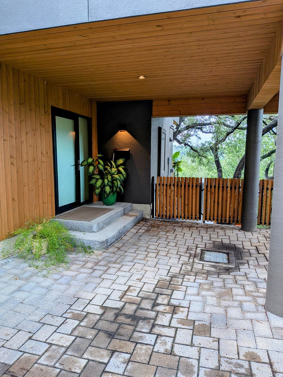 Private exterior entrance next to partially covered parking space.