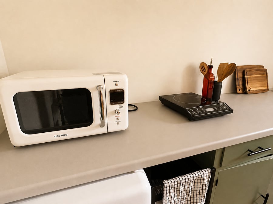 Kitchen essentials including microwave and cooktop.