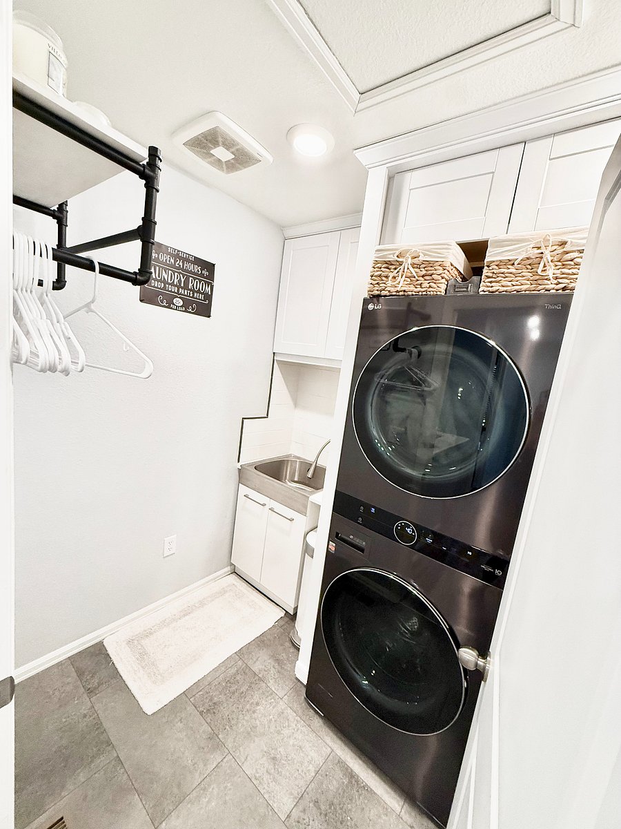Laundry Room: Features a washer and dryer, utility sink, and built-in drying rank. It is equipped with an ironing board, iron, and steamer.