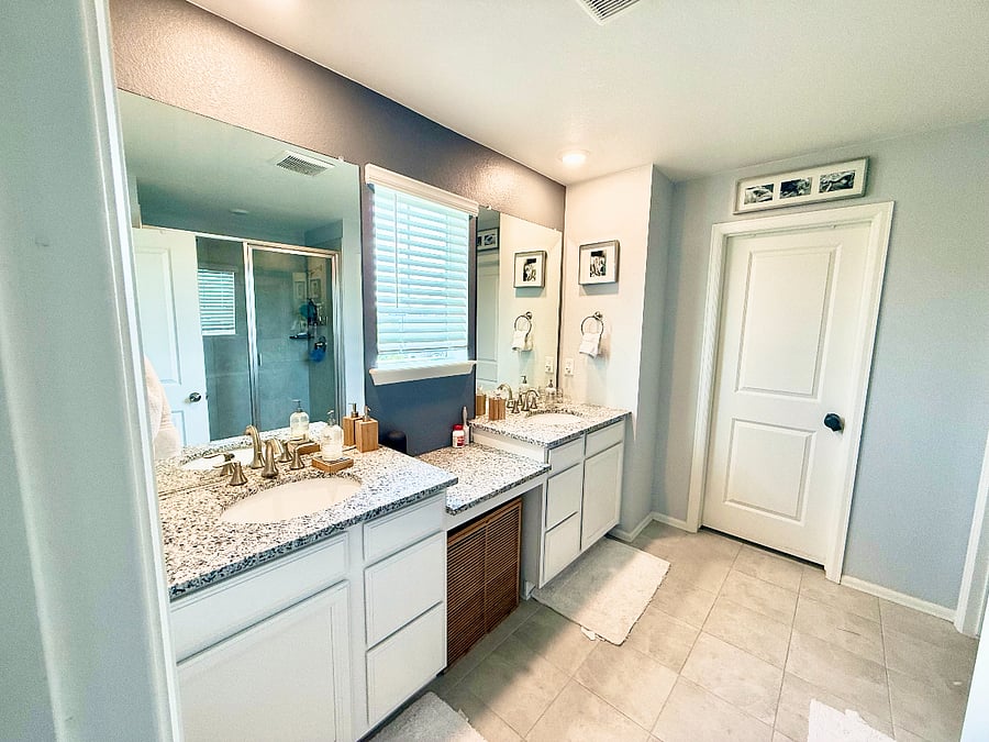 Primary Bathroom: Attached to the Primary Bedroom suite featuing double sinks, powder station, large walk-in shower, and private toilet.